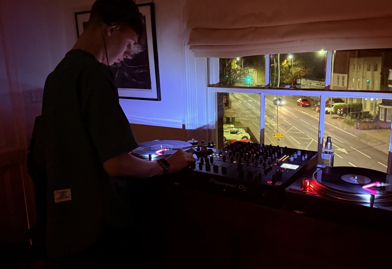 Mixing at night by the window, cue light glowing red, the street lit up outside.